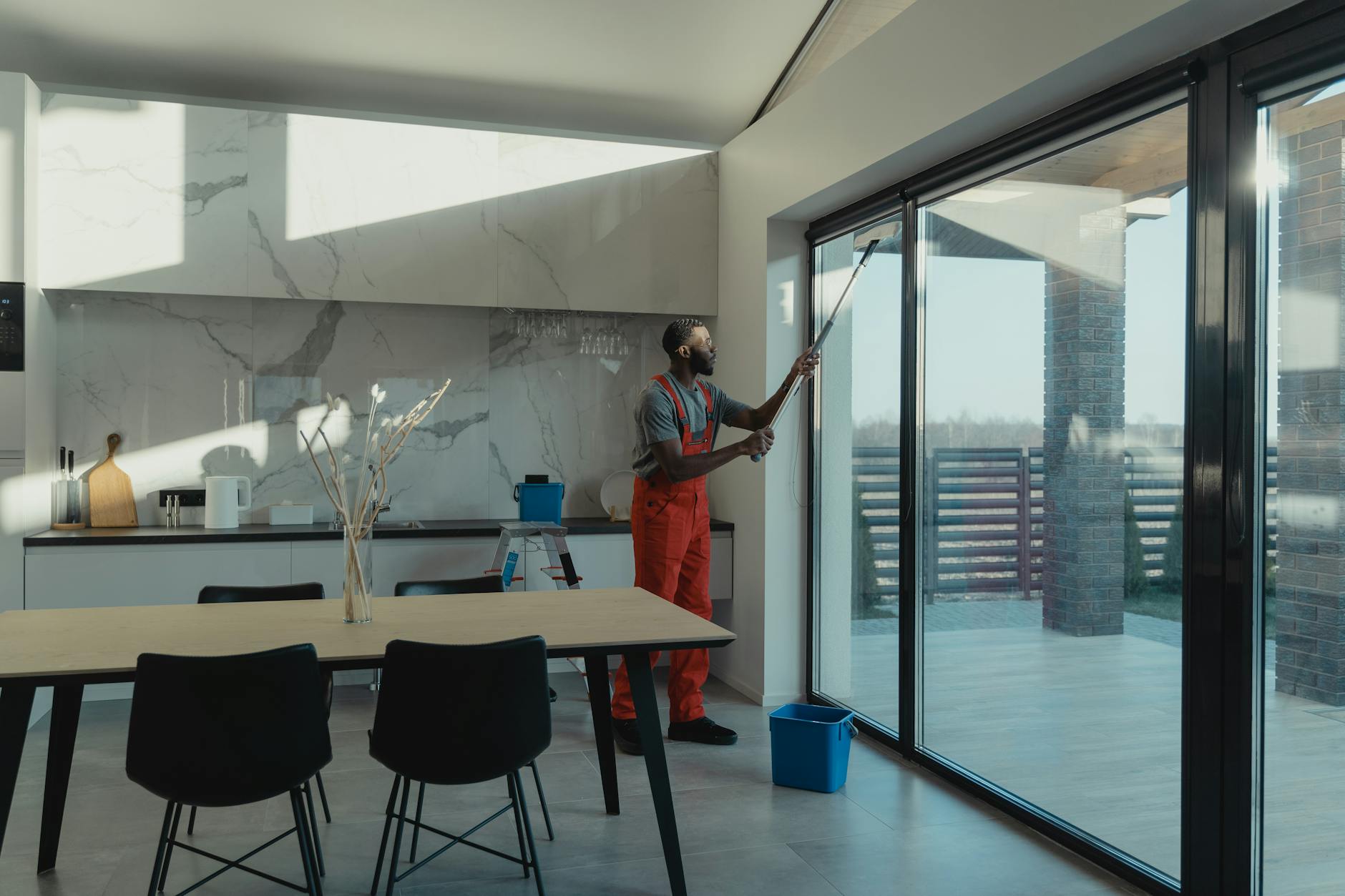 Professional cleaner tidying a bright modern kitchen